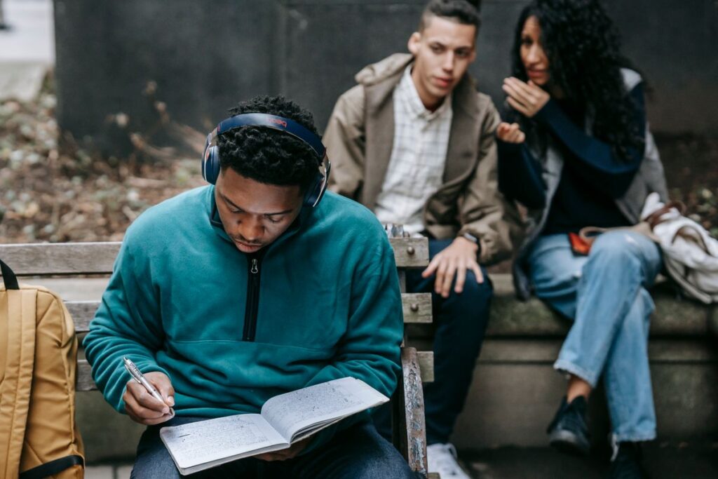 Student wearing headphones while studying on campus