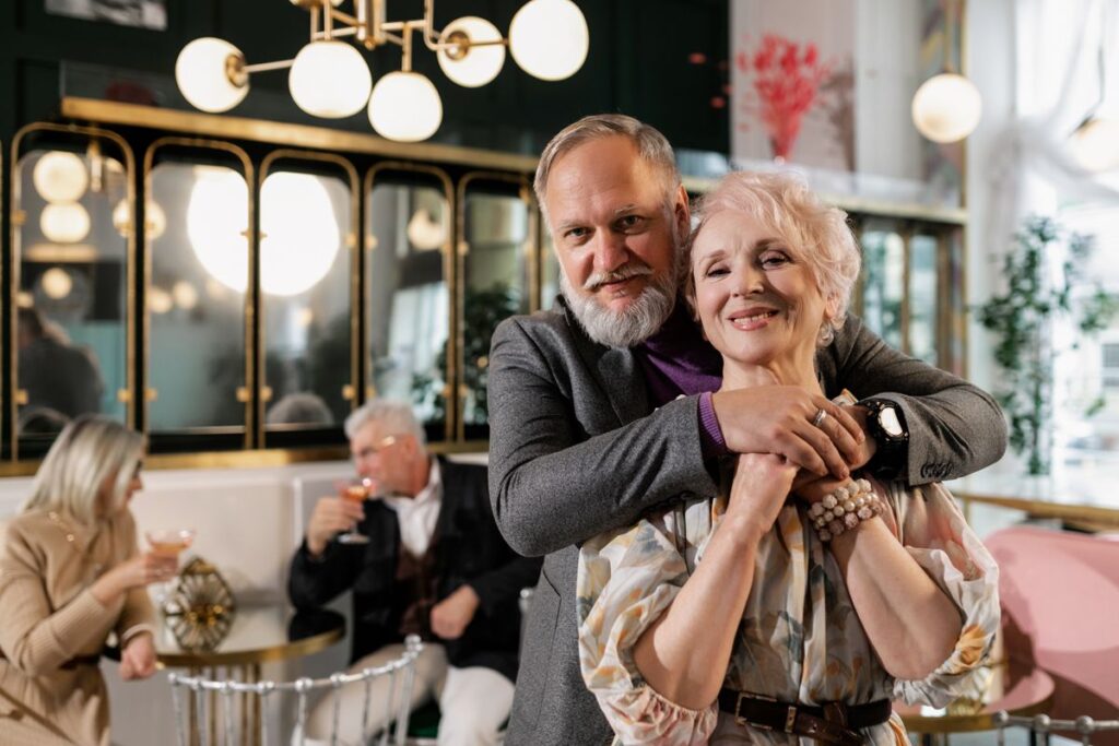 Smiling couple standing together in a stylish restaurant with diners behind them