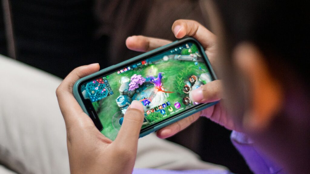 Hände spielen ein farbenfrohes Spiel auf dem Smartphone