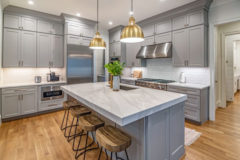 Bright remodeled kitchen with a marble island and pendant lights