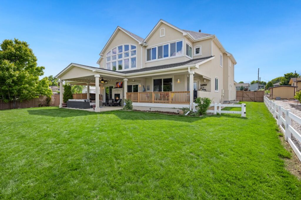 Two-story suburban house with a covered porch and a large green lawn