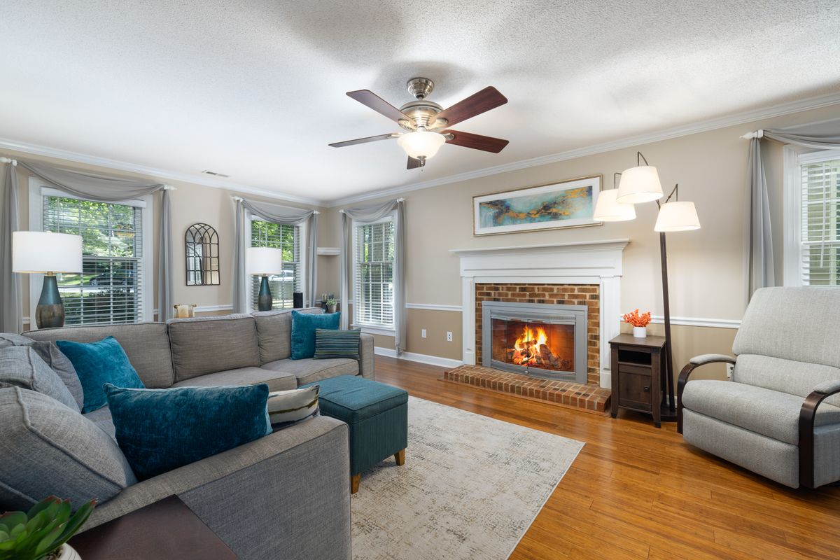 Living room with a fireplace, sofa and armchairs inside a family home