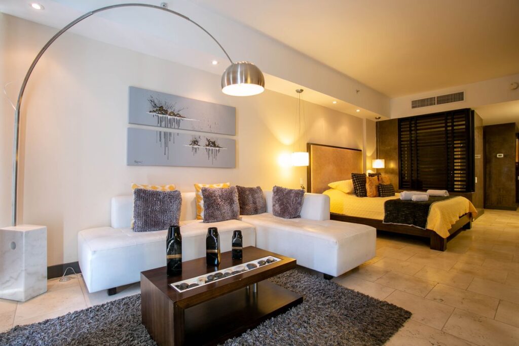 Romslig hotellsuite med sofagruppe og dobbeltseng