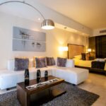 Romslig hotellsuite med sofagruppe og dobbeltseng