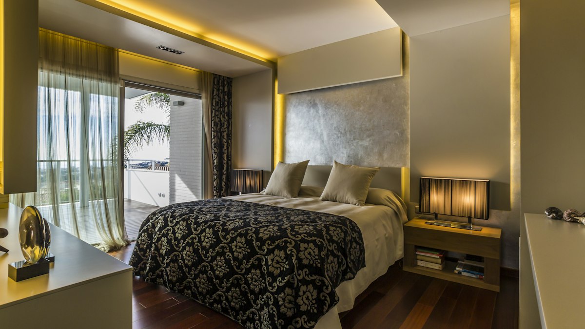 Lyxigt hotellrum med mönstrat sängöverkast och stora fönster
