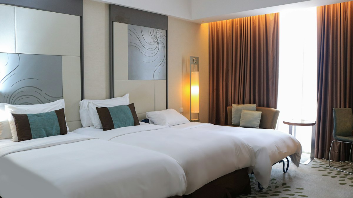 Rymligt hotellrum med två sängar och sittgrupp vid fönstret
