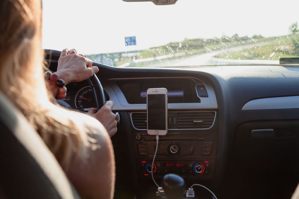 Driver with a phone mounted on the car dashboard