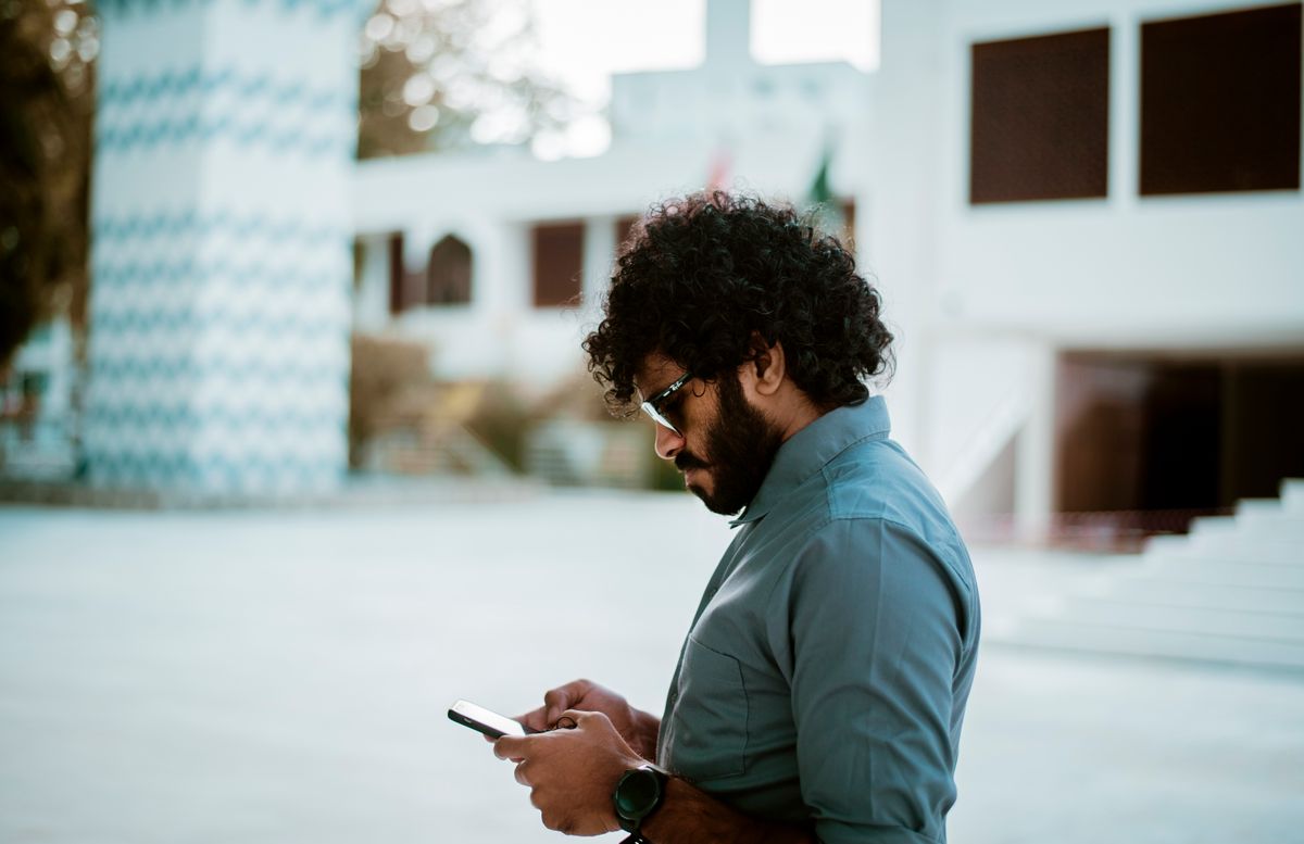 A man checking his phone outdoors