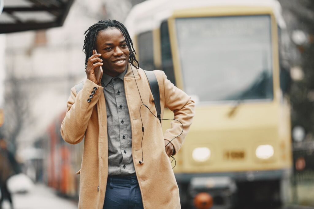 A man taking a call beside a tram