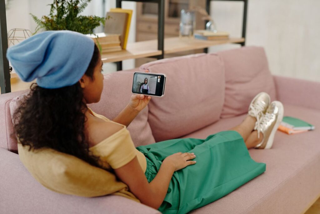 A woman watching video on her phone on a sofa