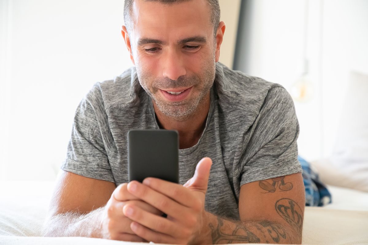 A man smiling at his phone