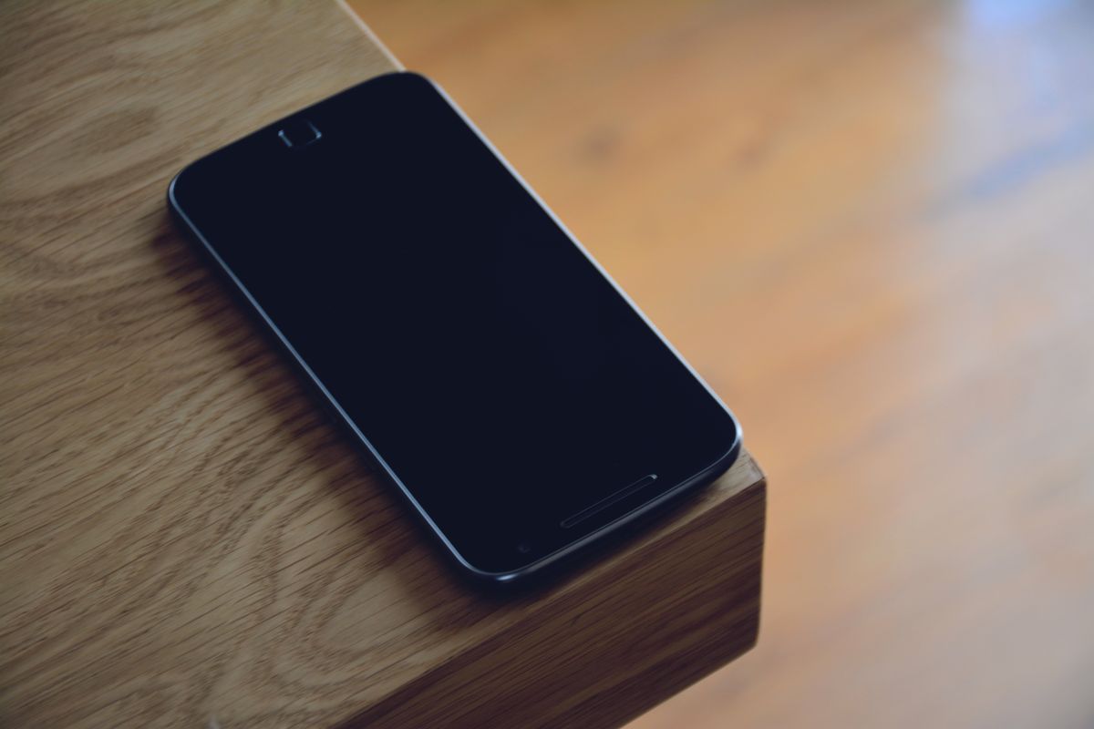 A phone resting on a wooden table