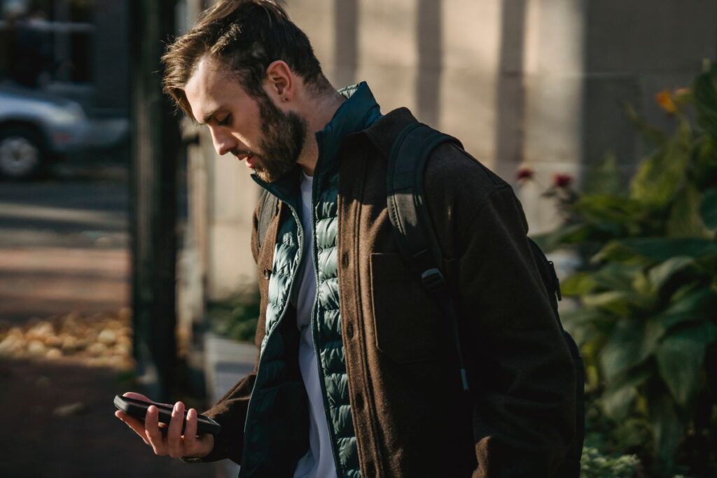 A man checking his phone on a city street