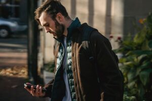 A man checking his phone on a city street