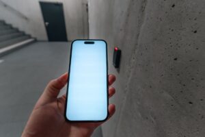 A hand holding a phone with a blank screen
