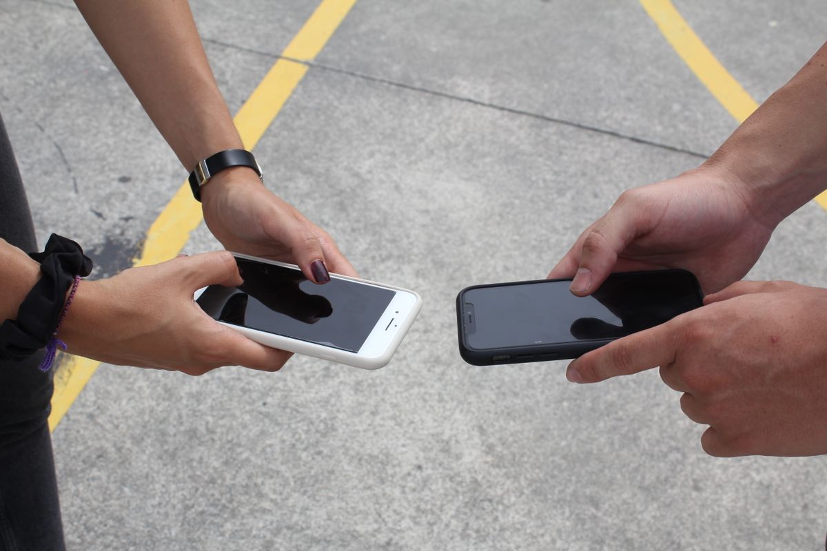 Two phones held side by side