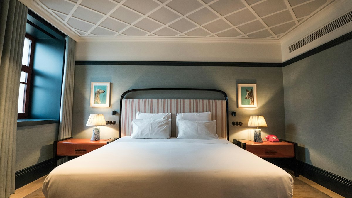 Elegant hotel room with a patterned ceiling, double bed and framed prints
