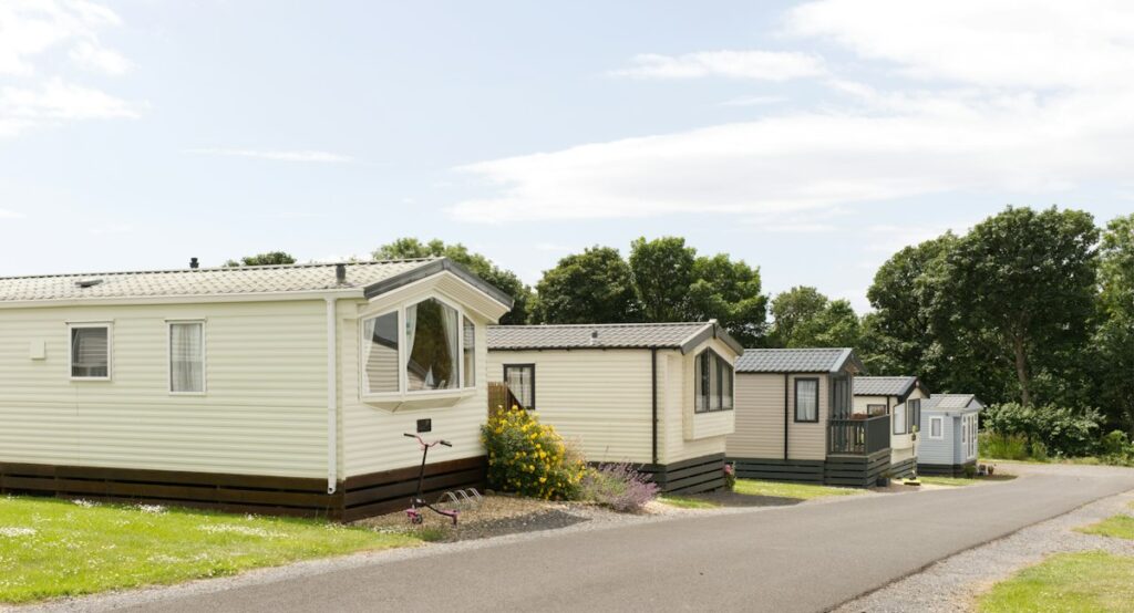 Row of mobile homes along a quiet road in a landscaped park