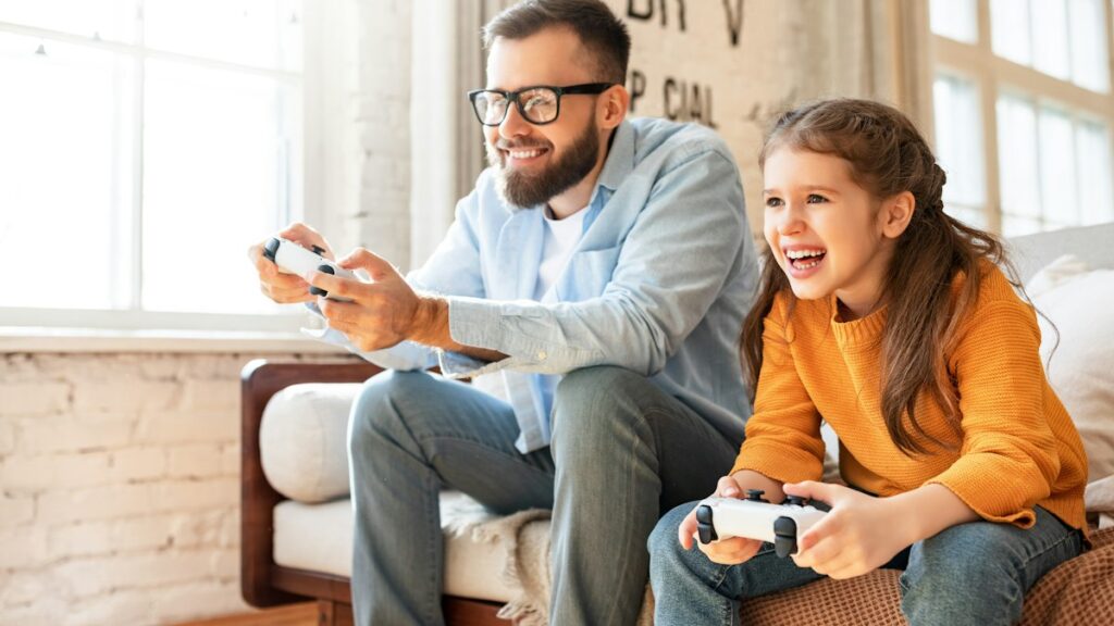 Father and daughter laughing while playing video games together