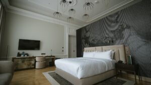 Elegant hotel bedroom with a king bed, patterned feature wall and designer pendant lights