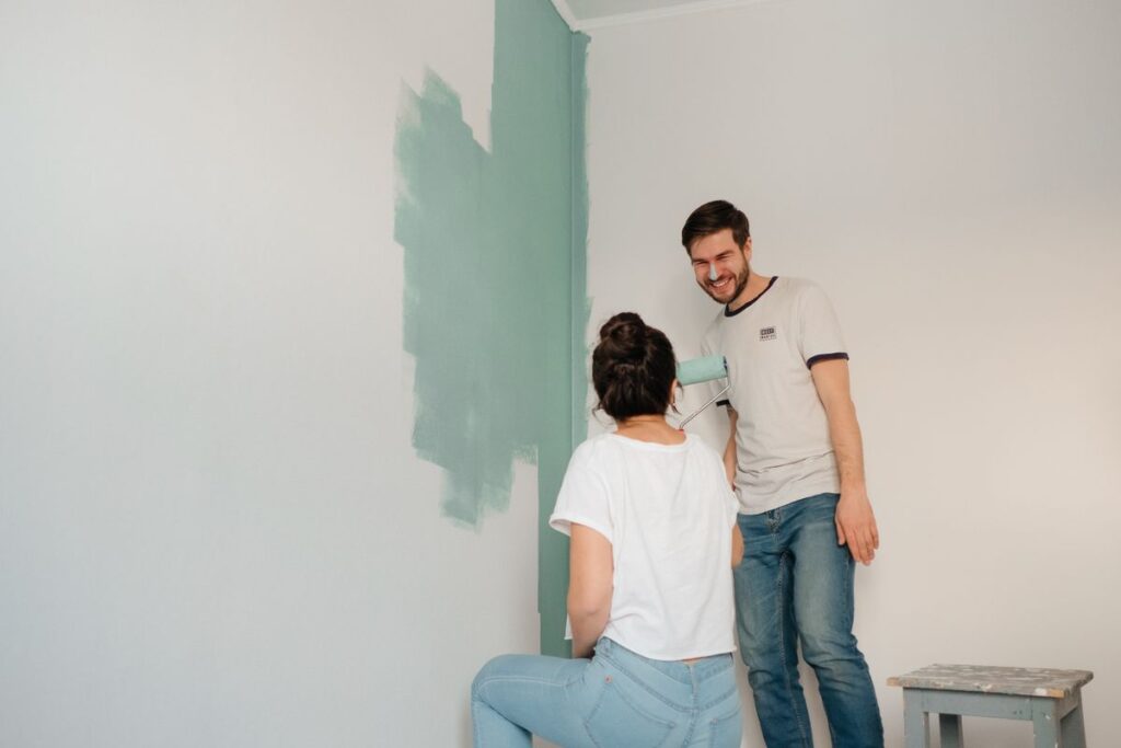 Personal Loans for Home Improvements, Moves and Medical Bills Couple painting a living room wall green