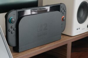 Nintendo Switch 2 resting in its dock beside a speaker