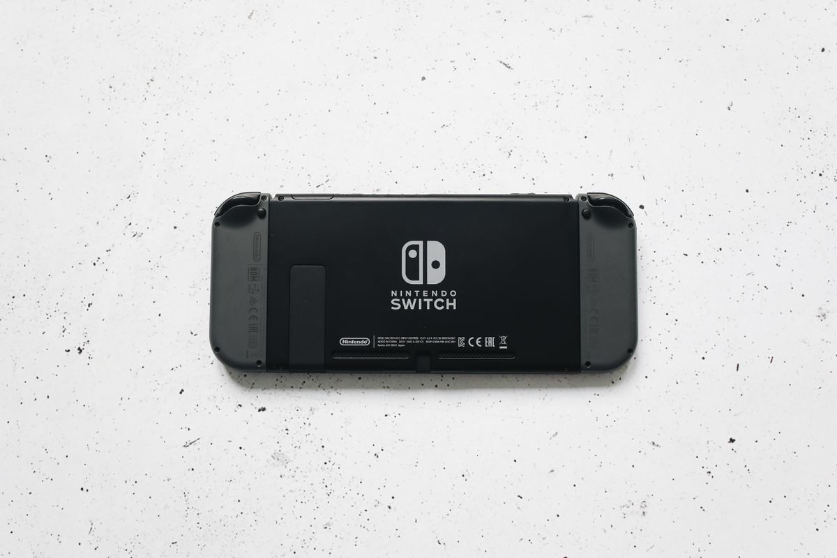 Back of a Nintendo Switch handheld on a speckled white surface