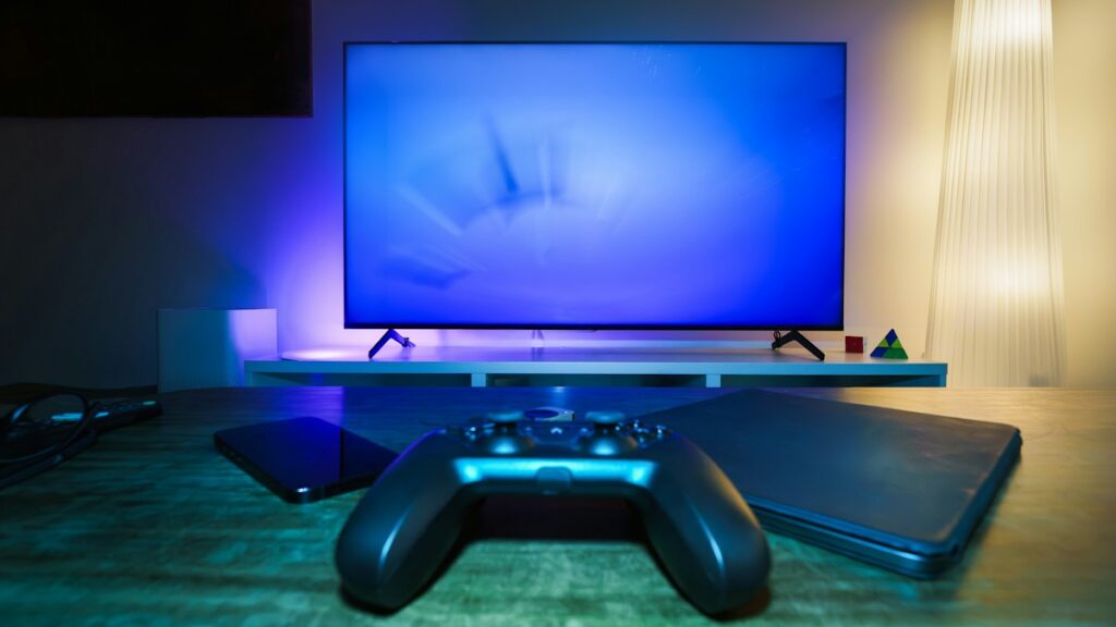 Pre-Owned Games to Fill a Console Backlog Games console standing beside a large television in a dimly lit living room