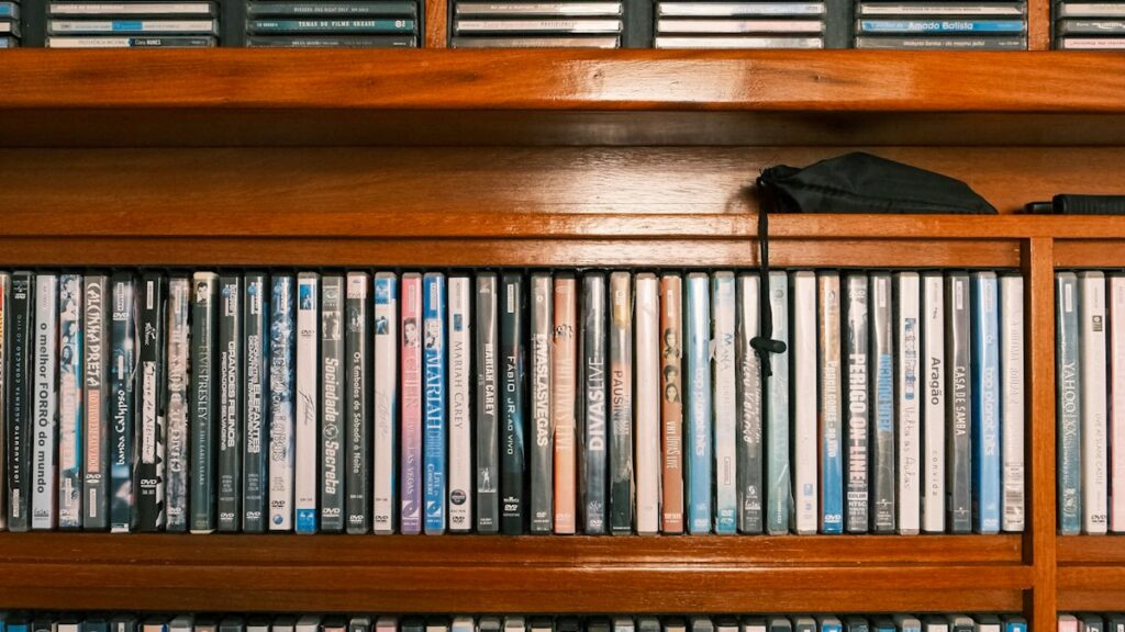 Rows of DVD cases filling a wooden wall shelf