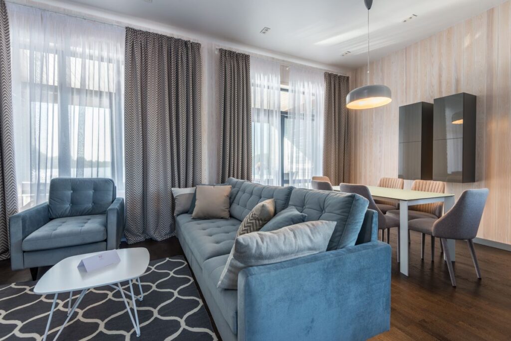 Rented apartment living room with a blue sofa, armchair and dining table