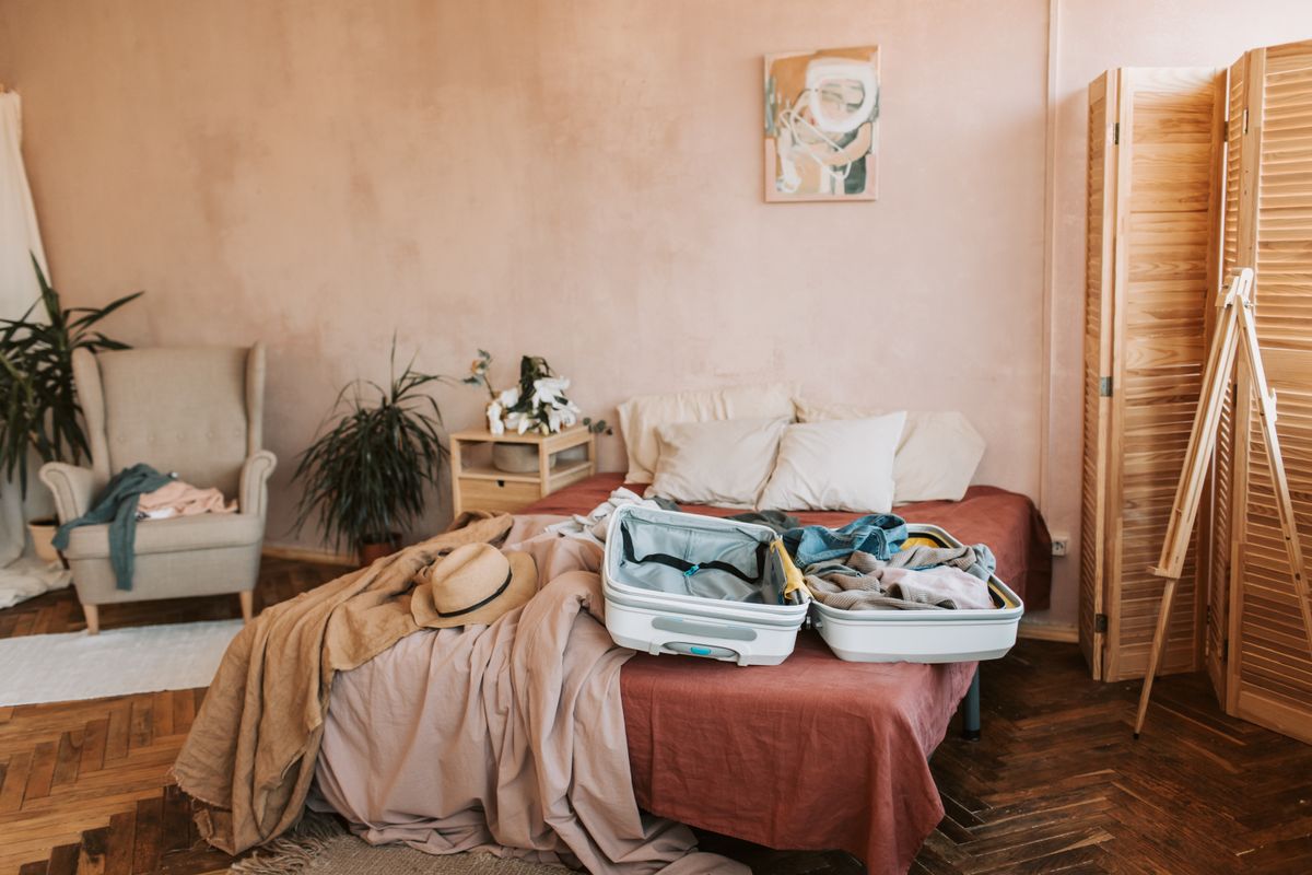 Open suitcase on a bed in a temporary room during a stay away from home