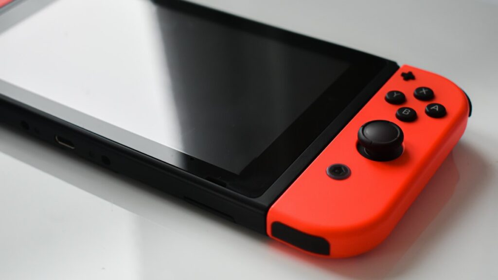Zelda-Spiele als Download-Code für die Nintendo Switch Nahaufnahme einer Handheld-Konsole mit rotem Controller